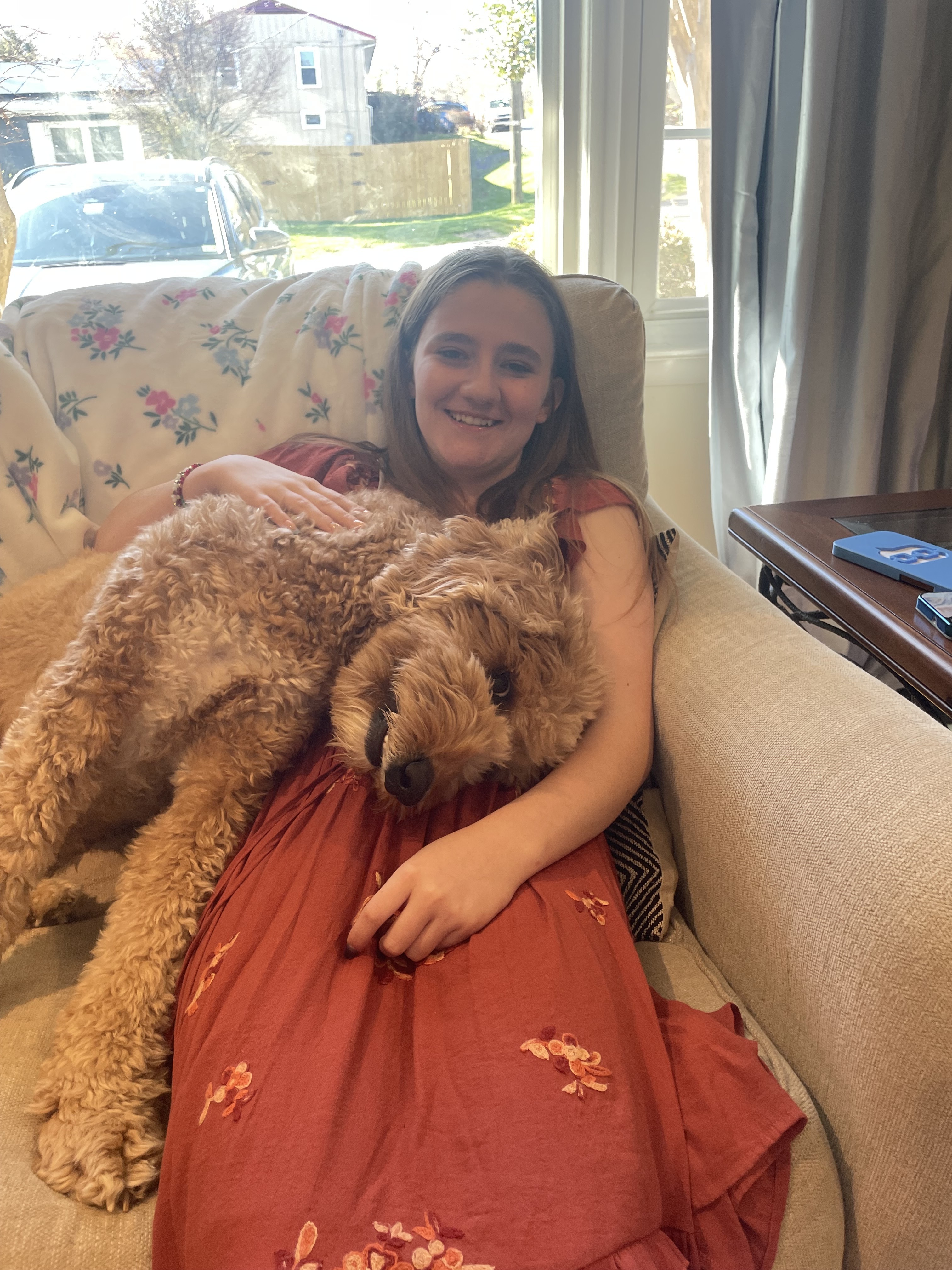 Selena Kelly smiling with a dog on the couch